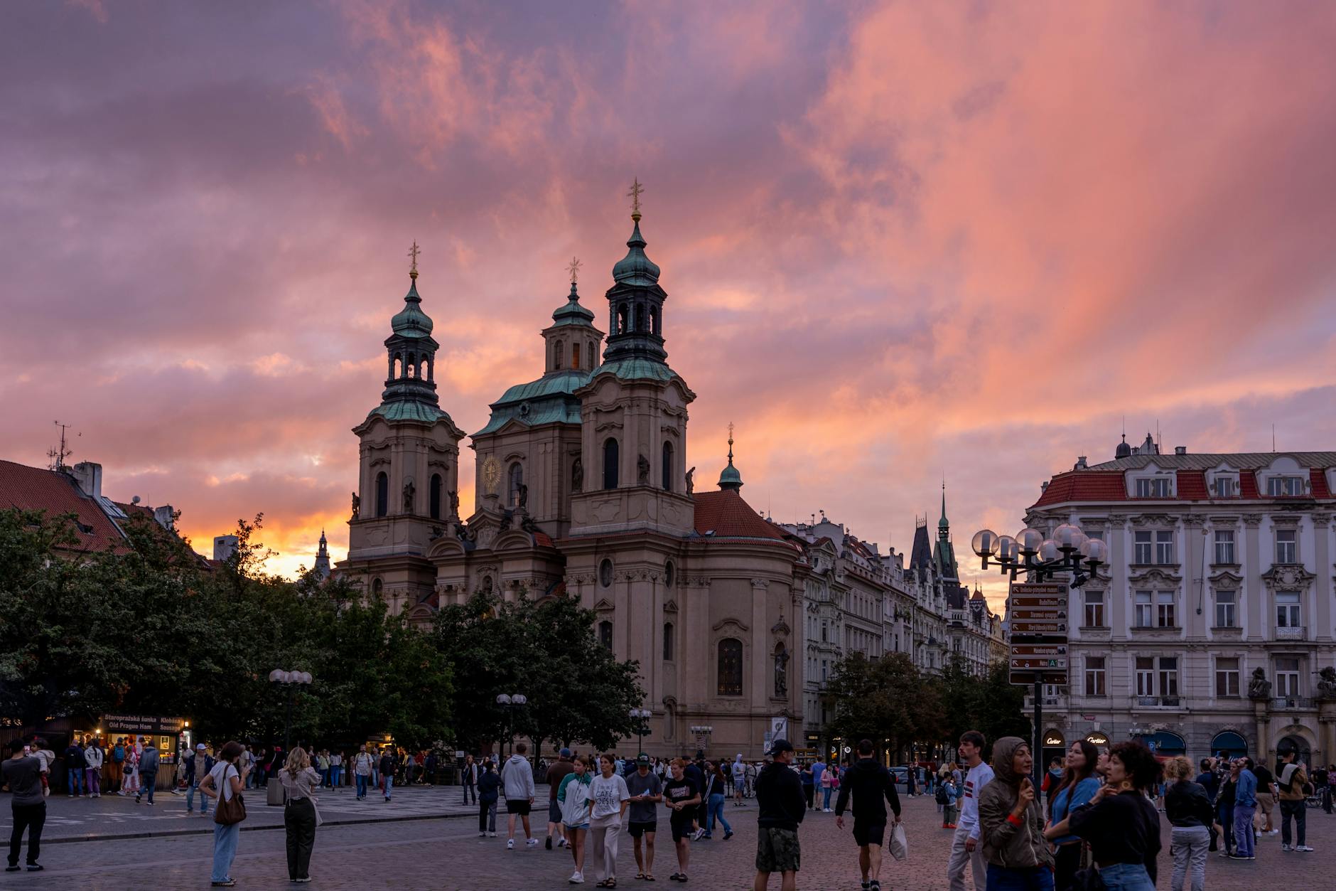 Sunset in Prague city square with church and people