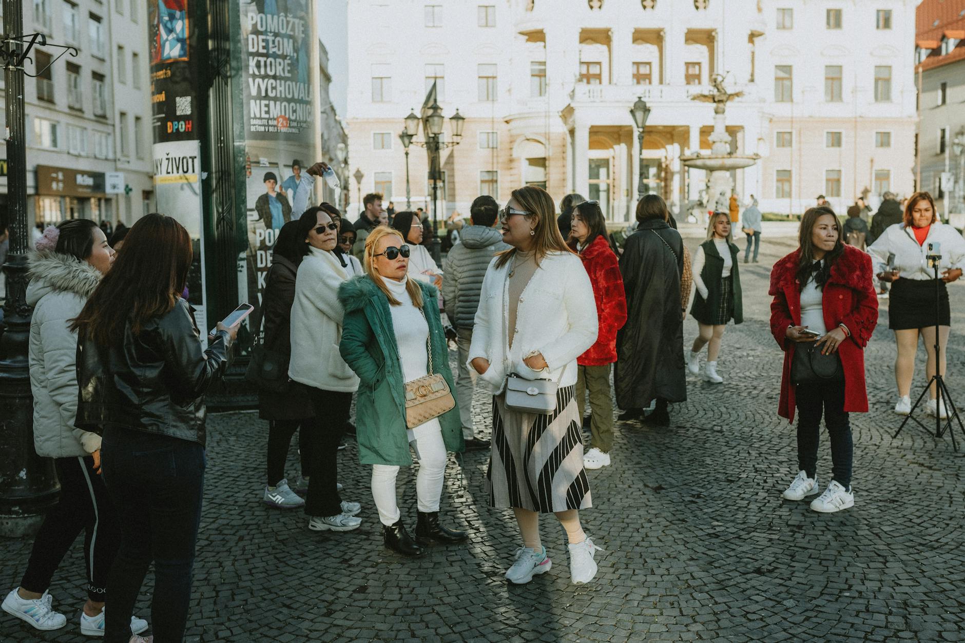 Women walking and socializing in Prague Old Town Square