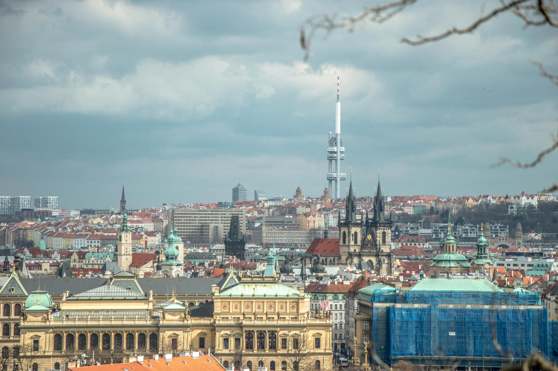 Panoramic Prague cityscape with towers under cloudy skies