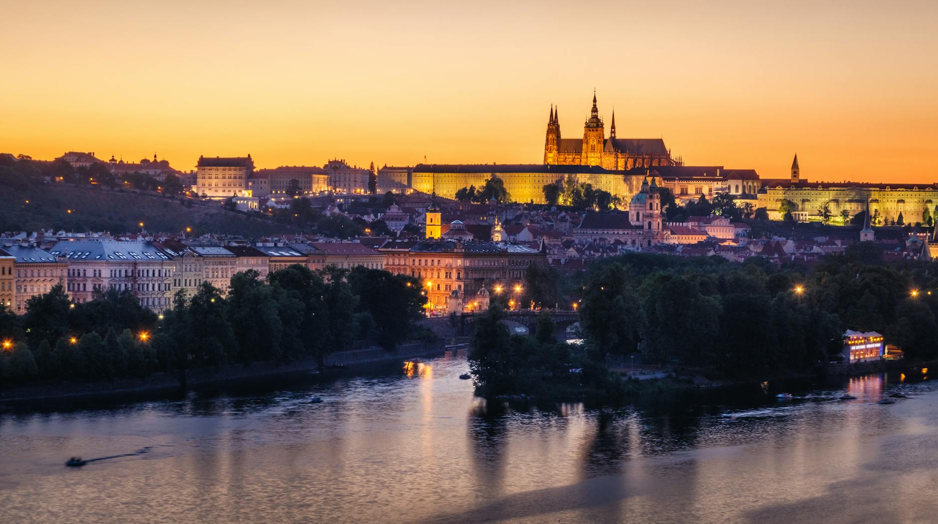 Prague Castle glowing at sunset over the Vltava River