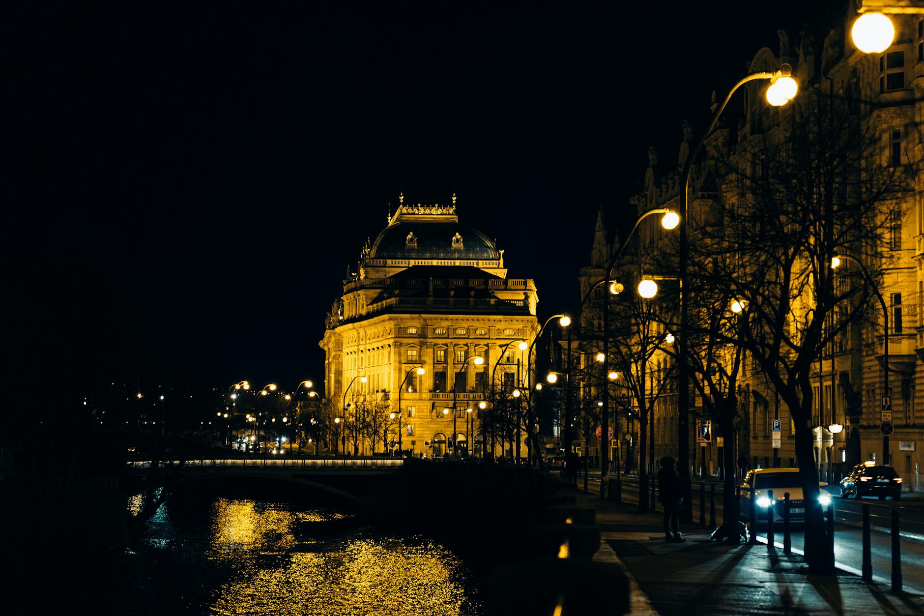 Illuminated National Theater in Prague at night by the river