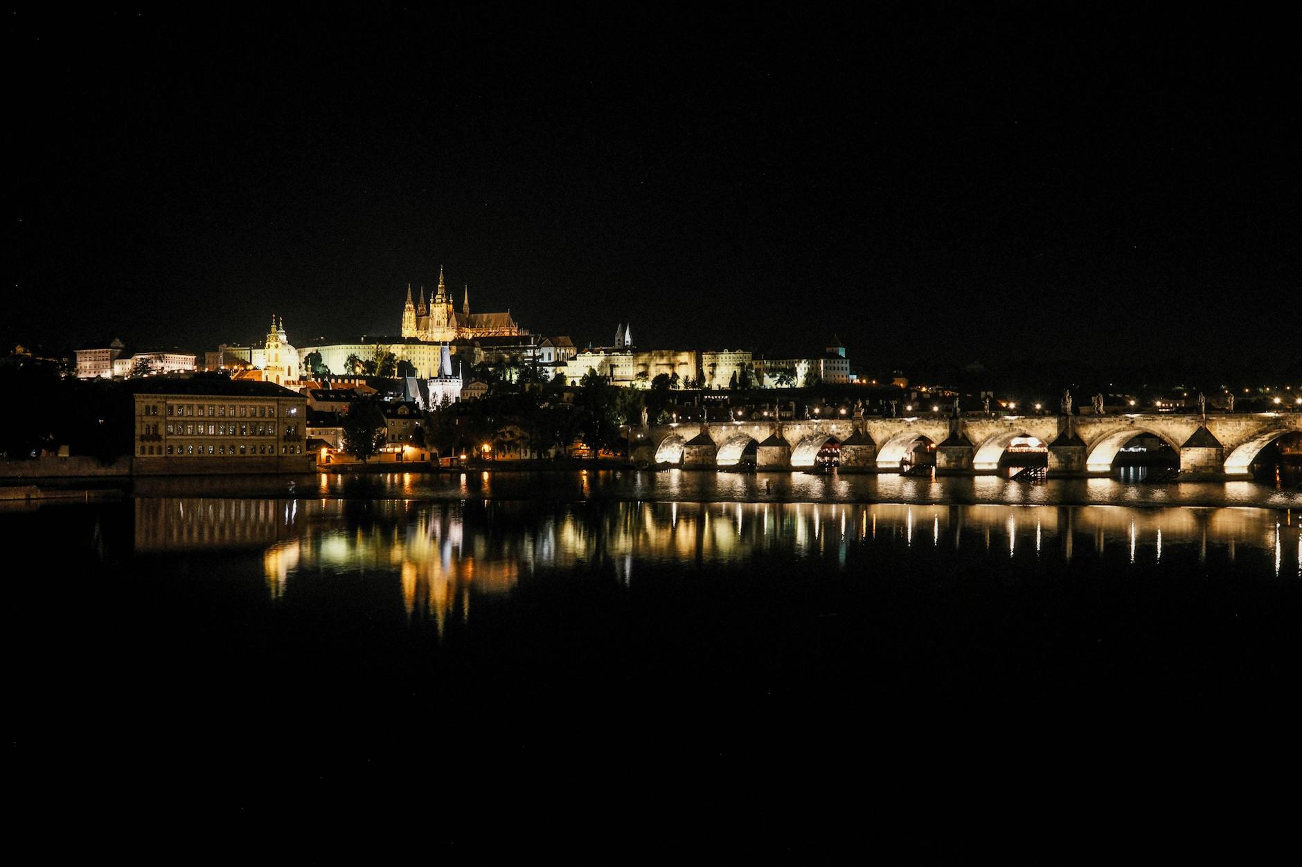 Prague Castle and Charles Bridge reflected on the Vltava River at night