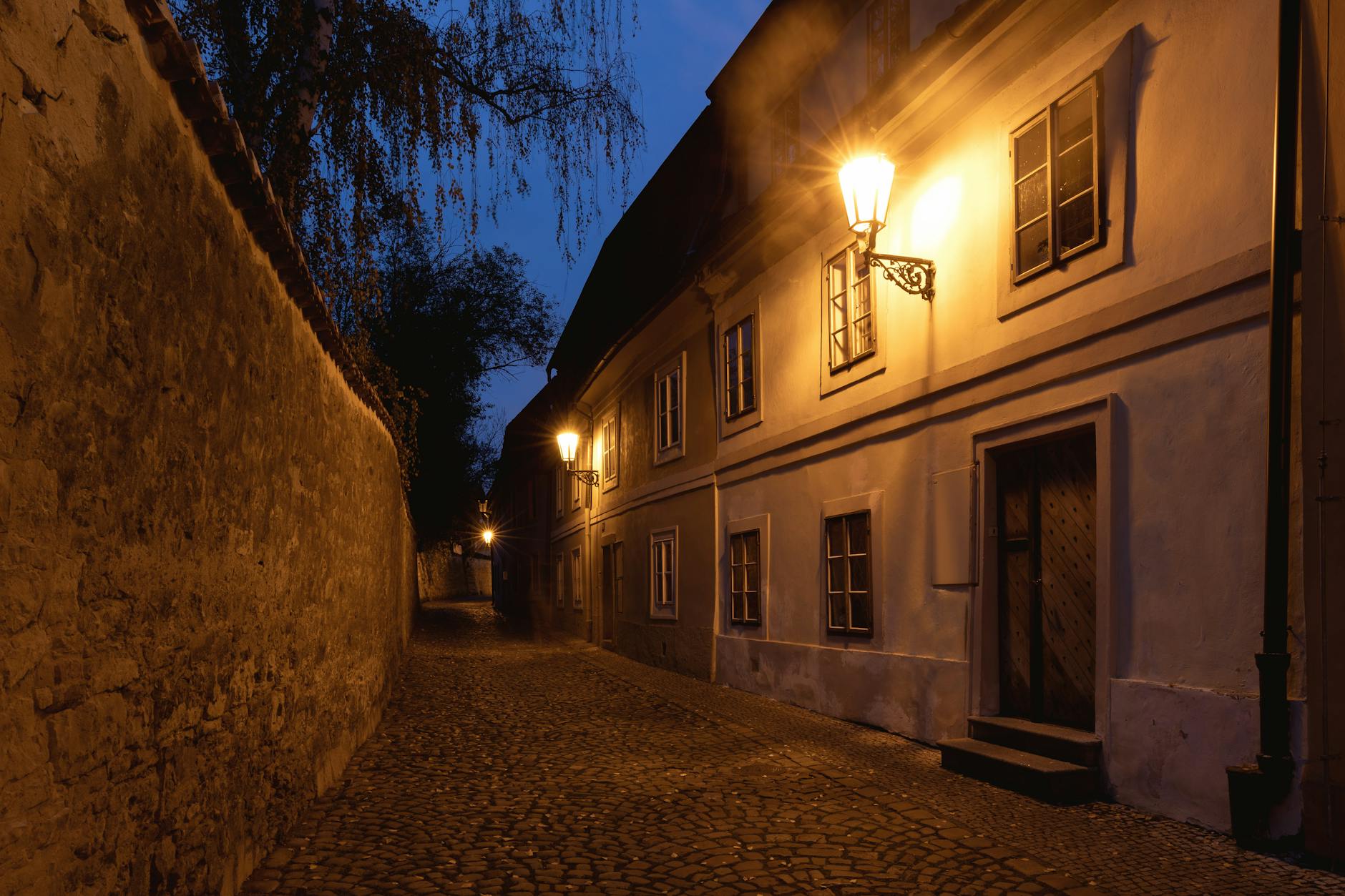 Illuminated cobblestone street in Prague at night