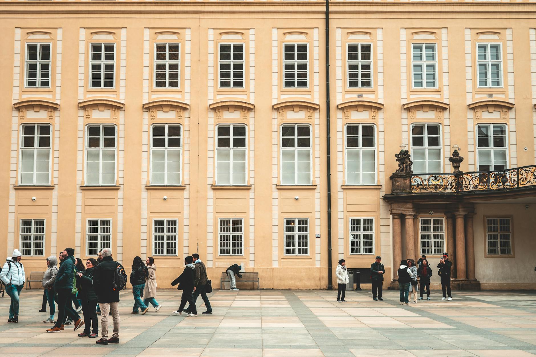 People strolling through a historic courtyard in Prague
