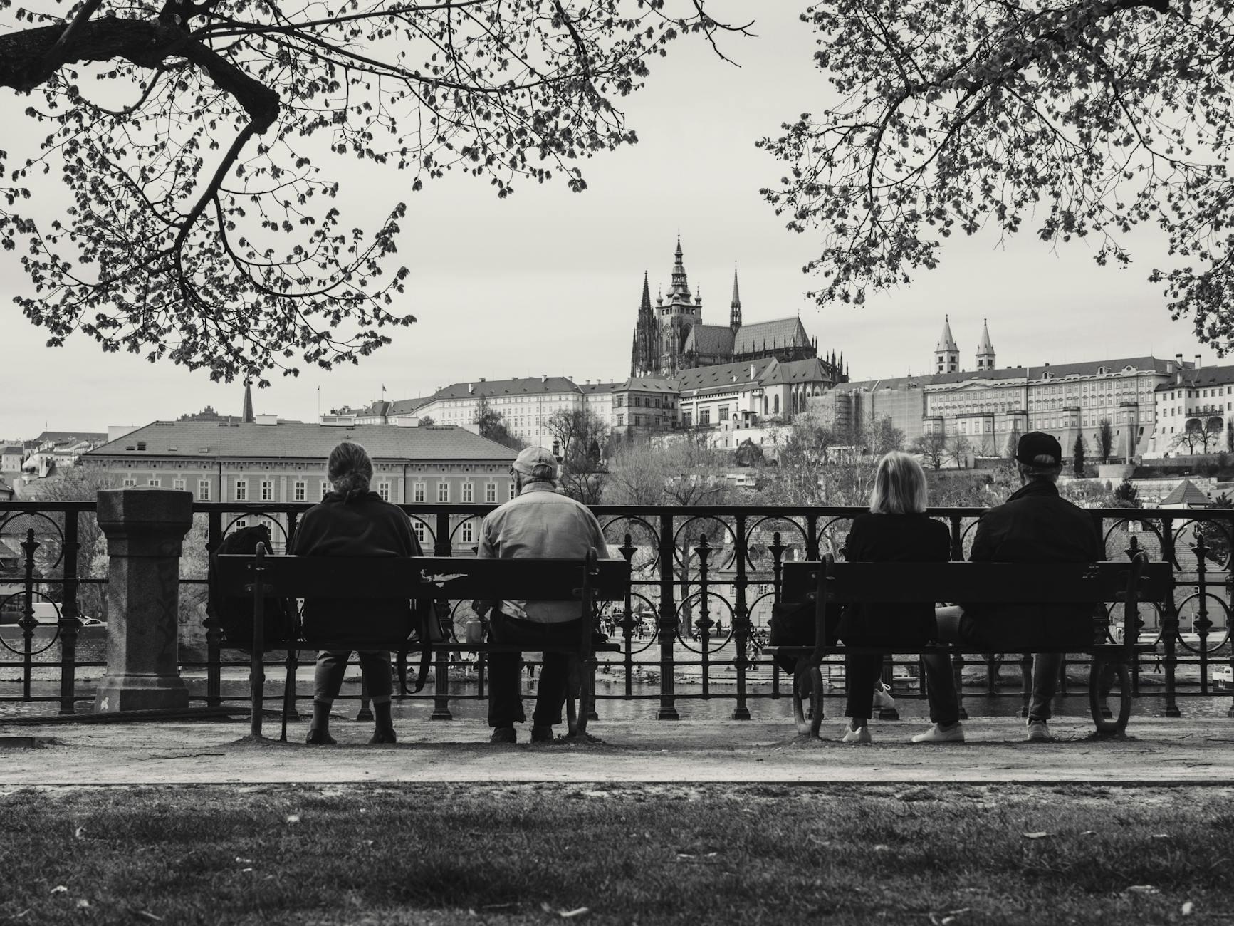 People on benches overlooking Prague Castle