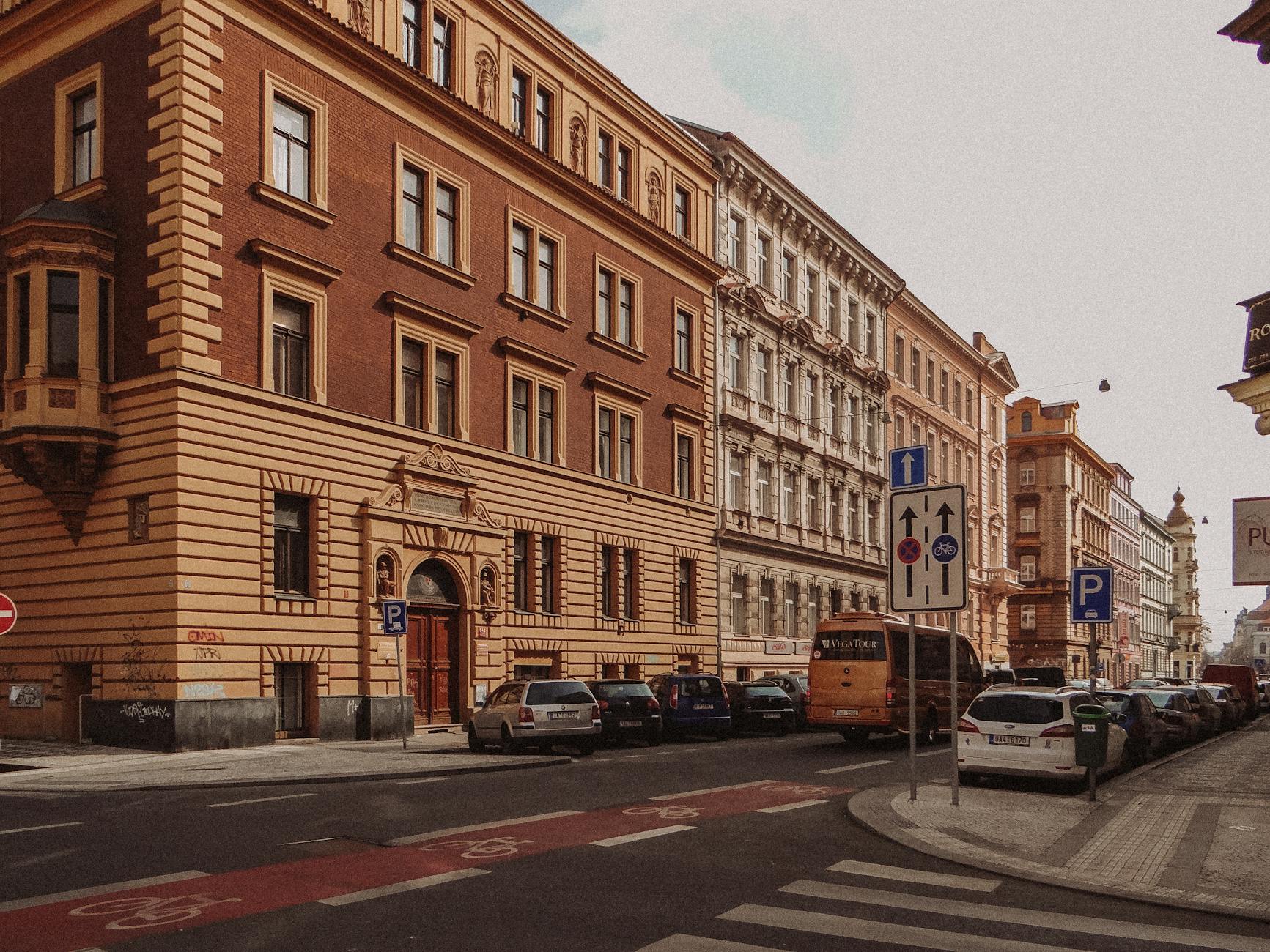 Historic Prague street with parked cars and classic buildings