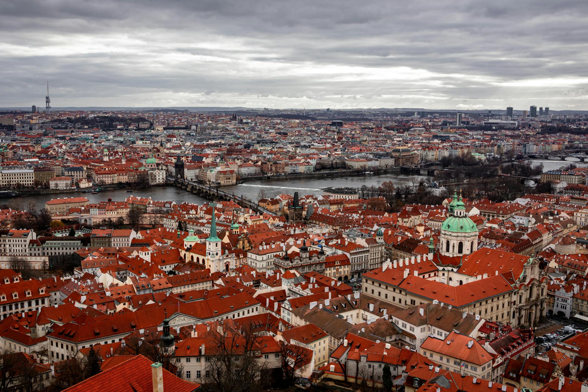 Aerial view of Prague red rooftops and the river under clouds