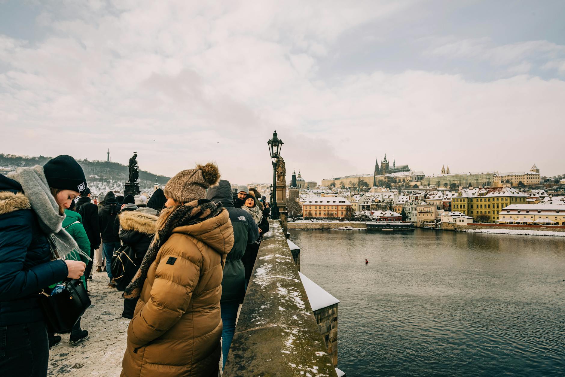 Crowds on Charles Bridge during a snowy Prague day