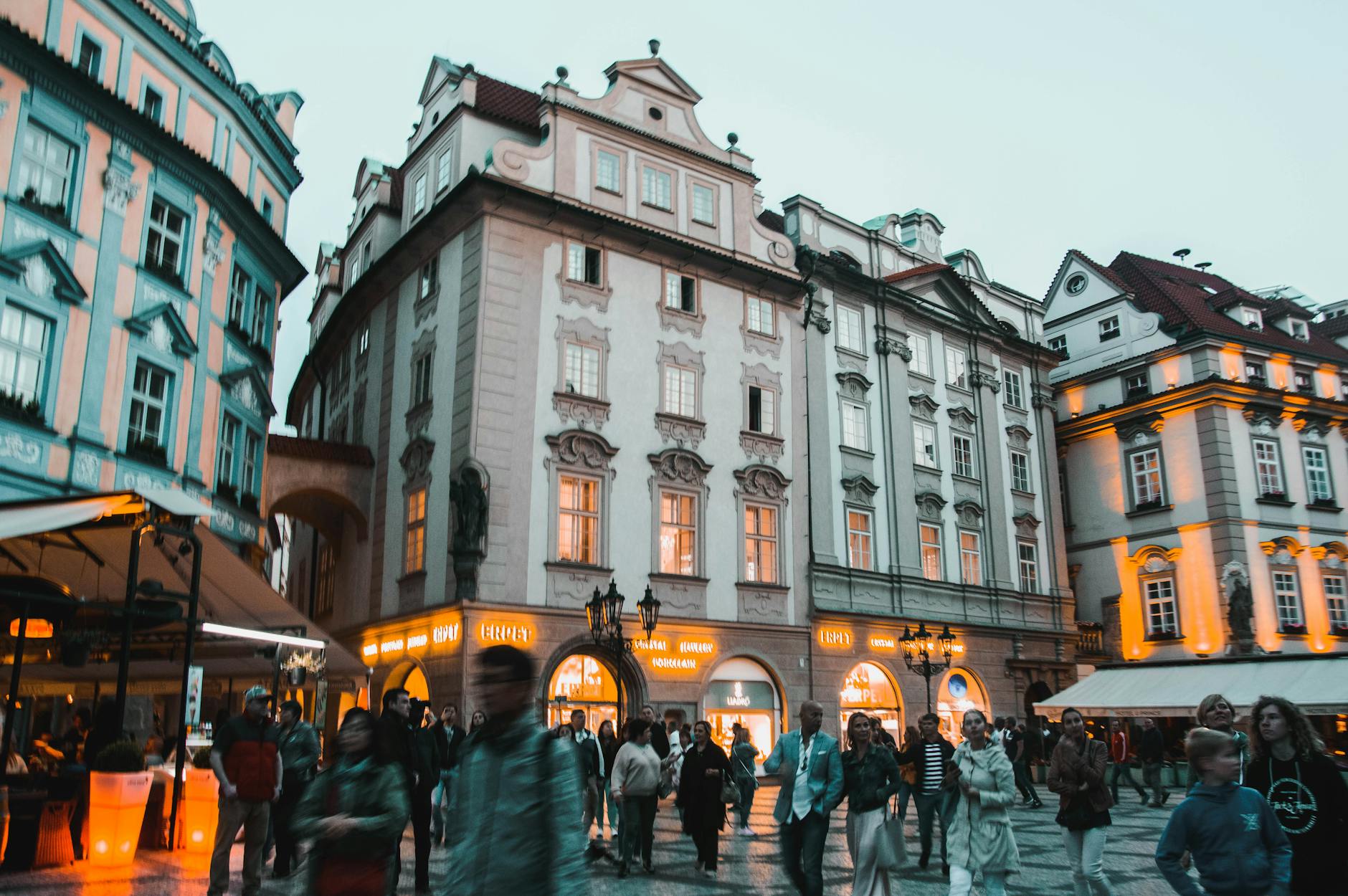 Busy Prague street at night with historic architecture