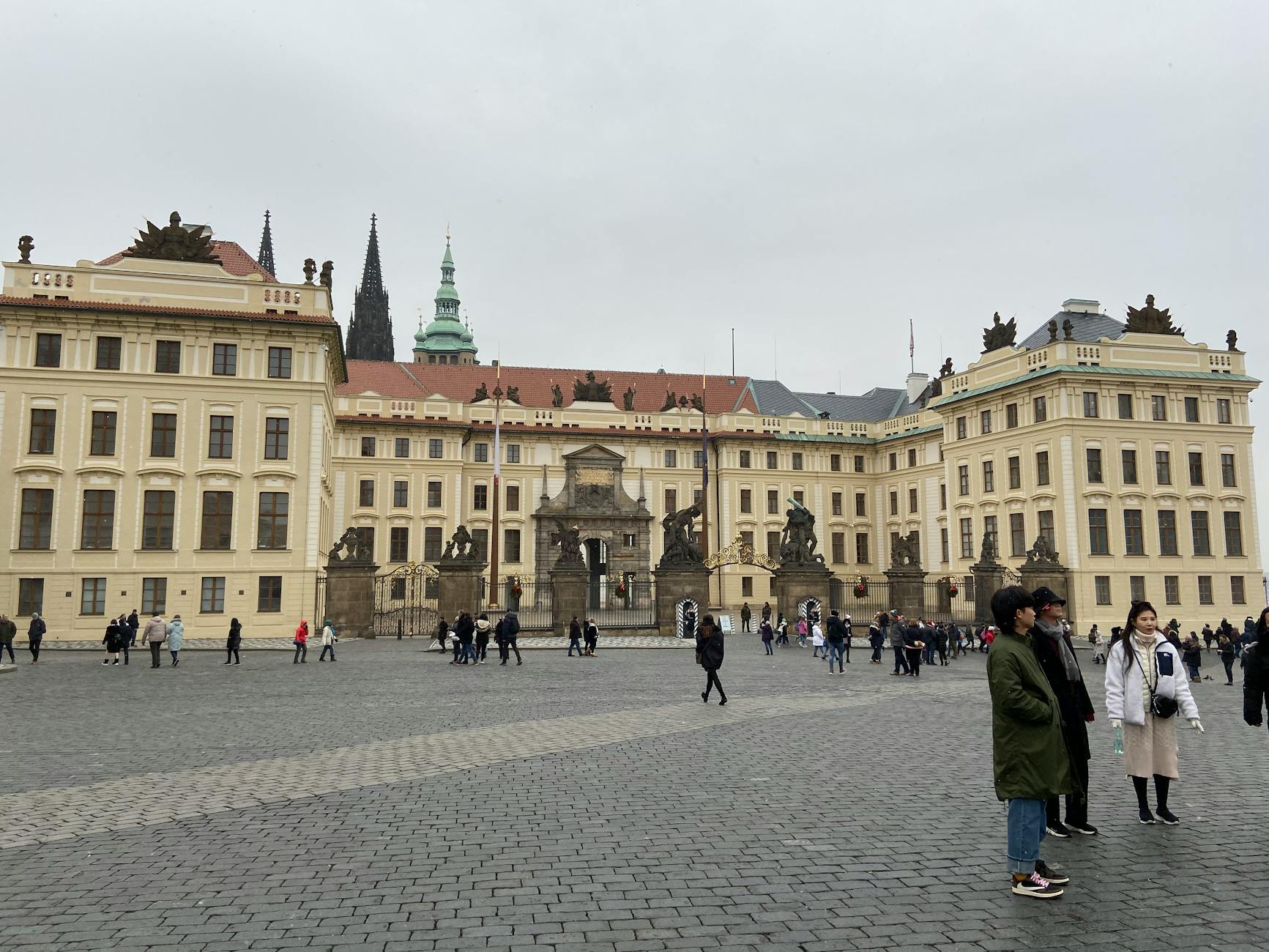 Visitors outside Prague Castle under a cloudy sky