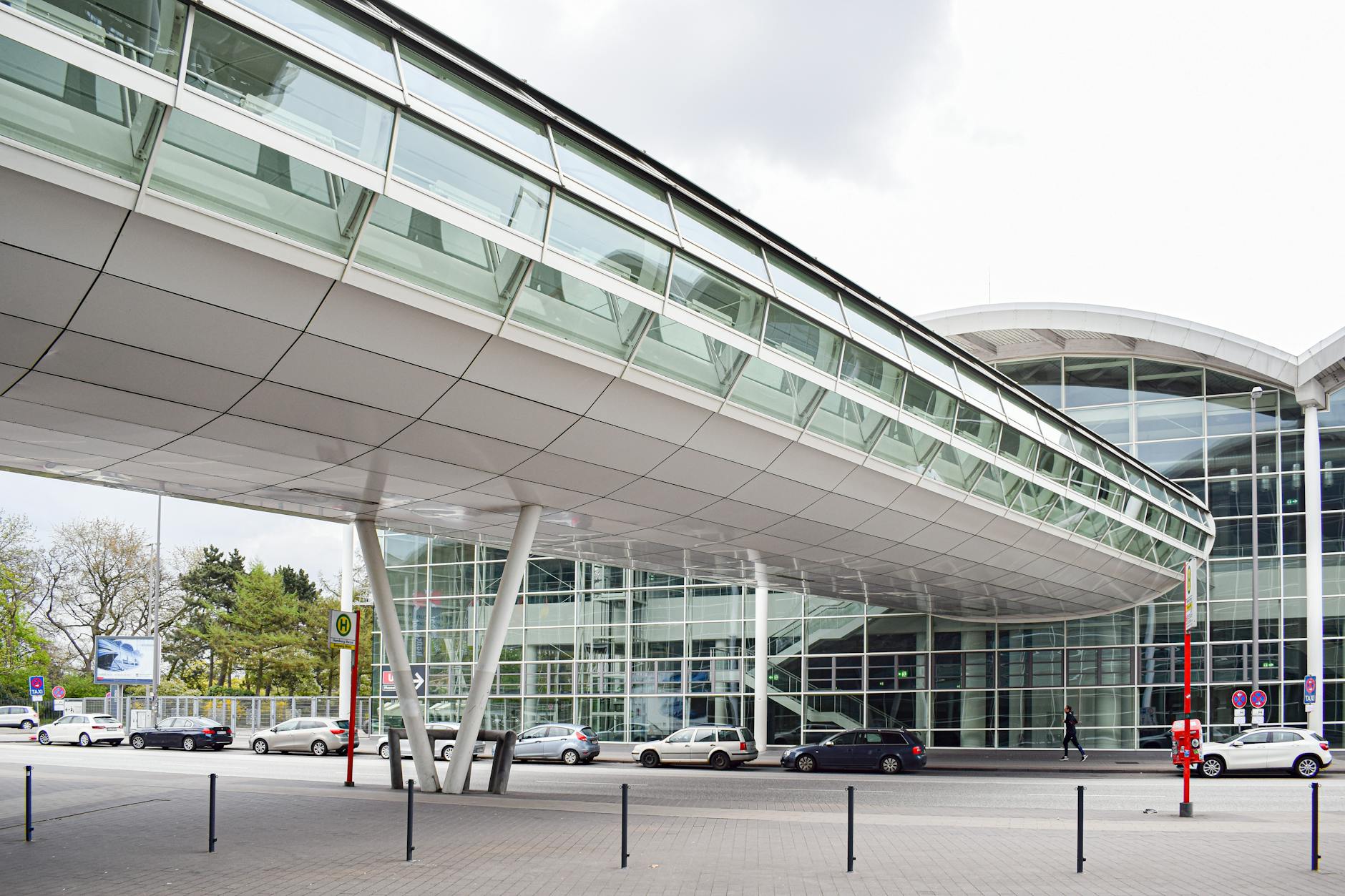 Glass trade-center architecture with skybridge and parked cars