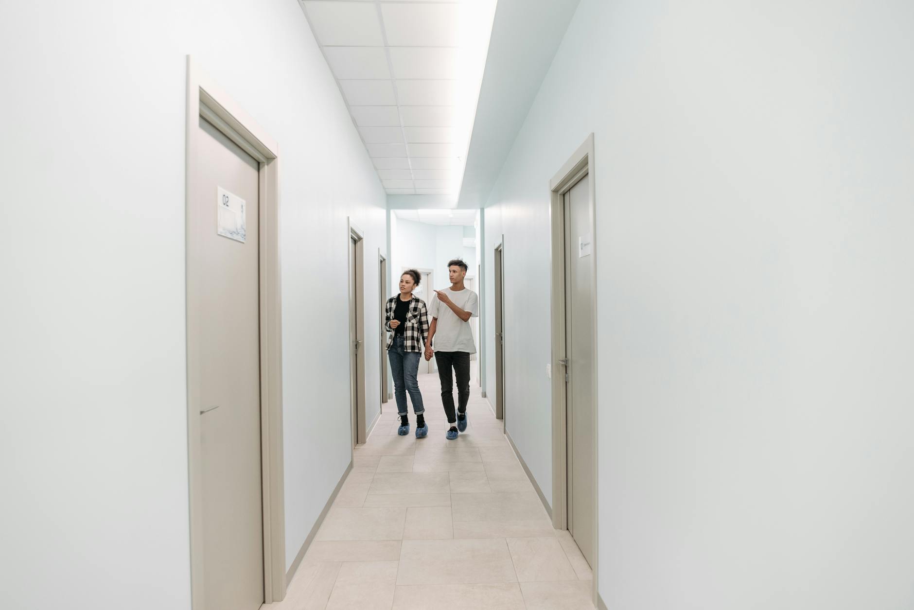Couple walking through a modern medical clinic corridor