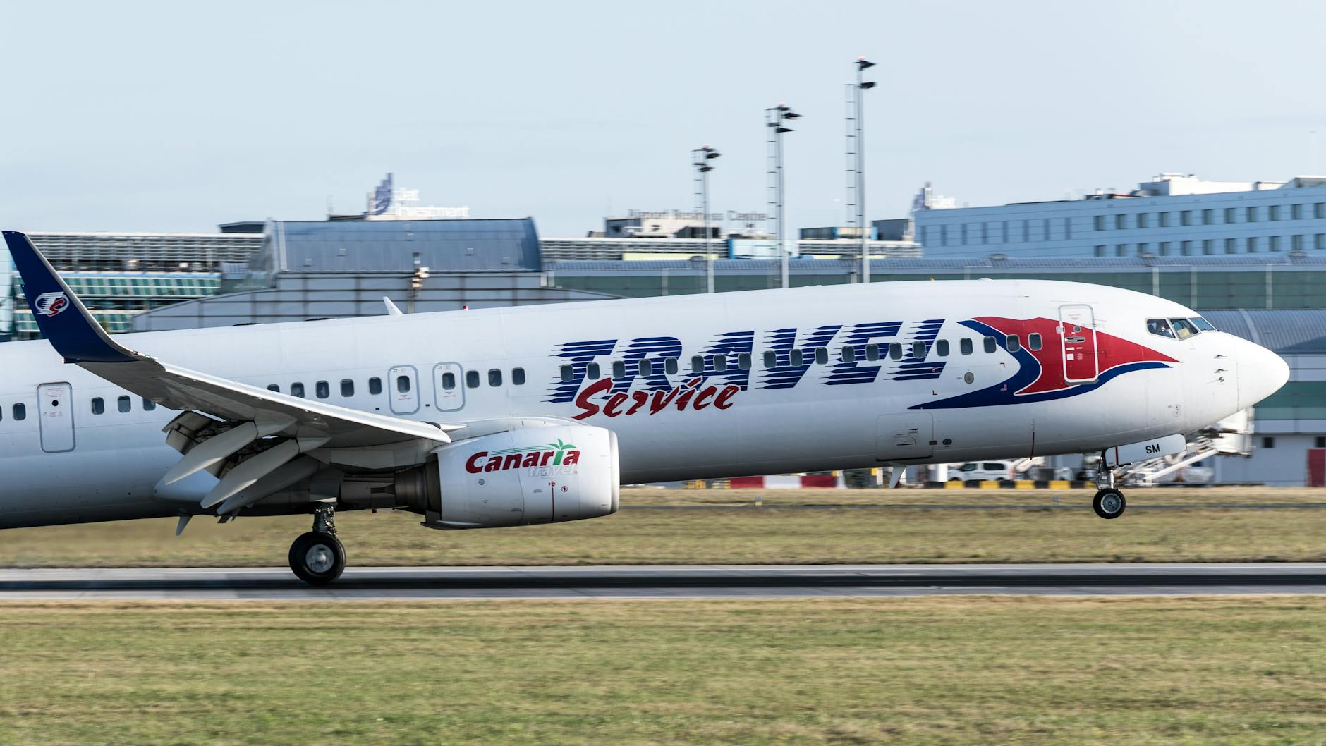 Airliner taking off at Prague airport with cityscape beyond