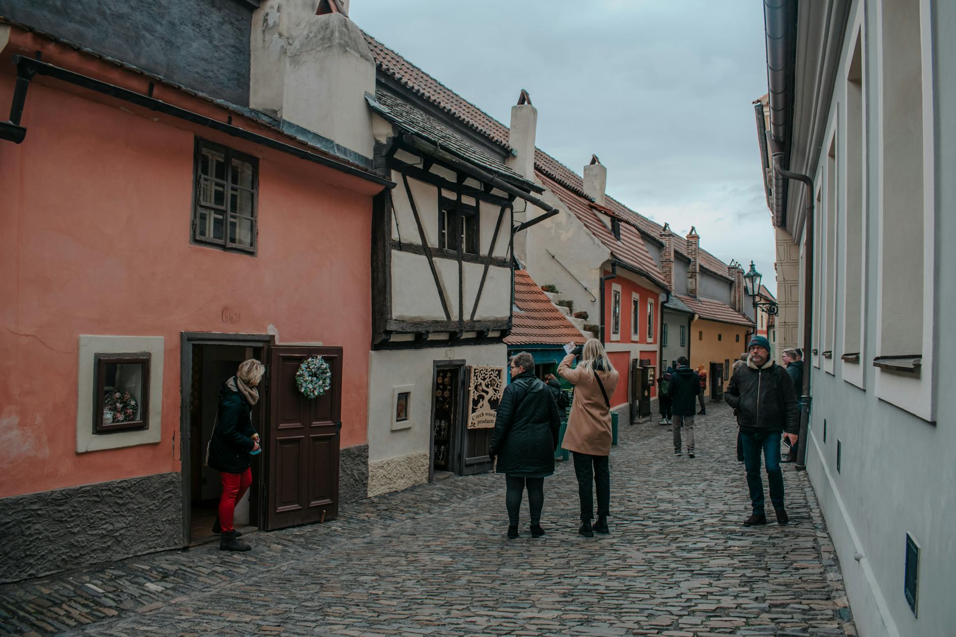 People walking along Prague Golden Lane by colorful medieval houses
