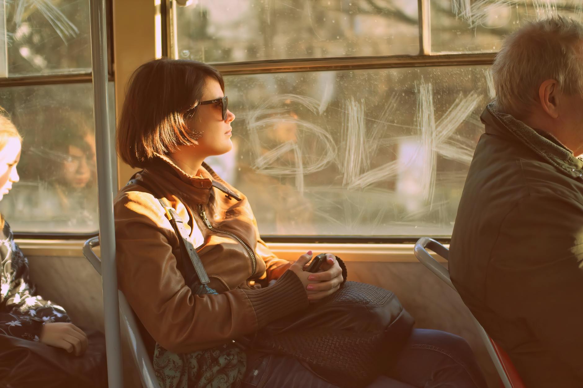 Woman riding a Prague tram in warm evening light
