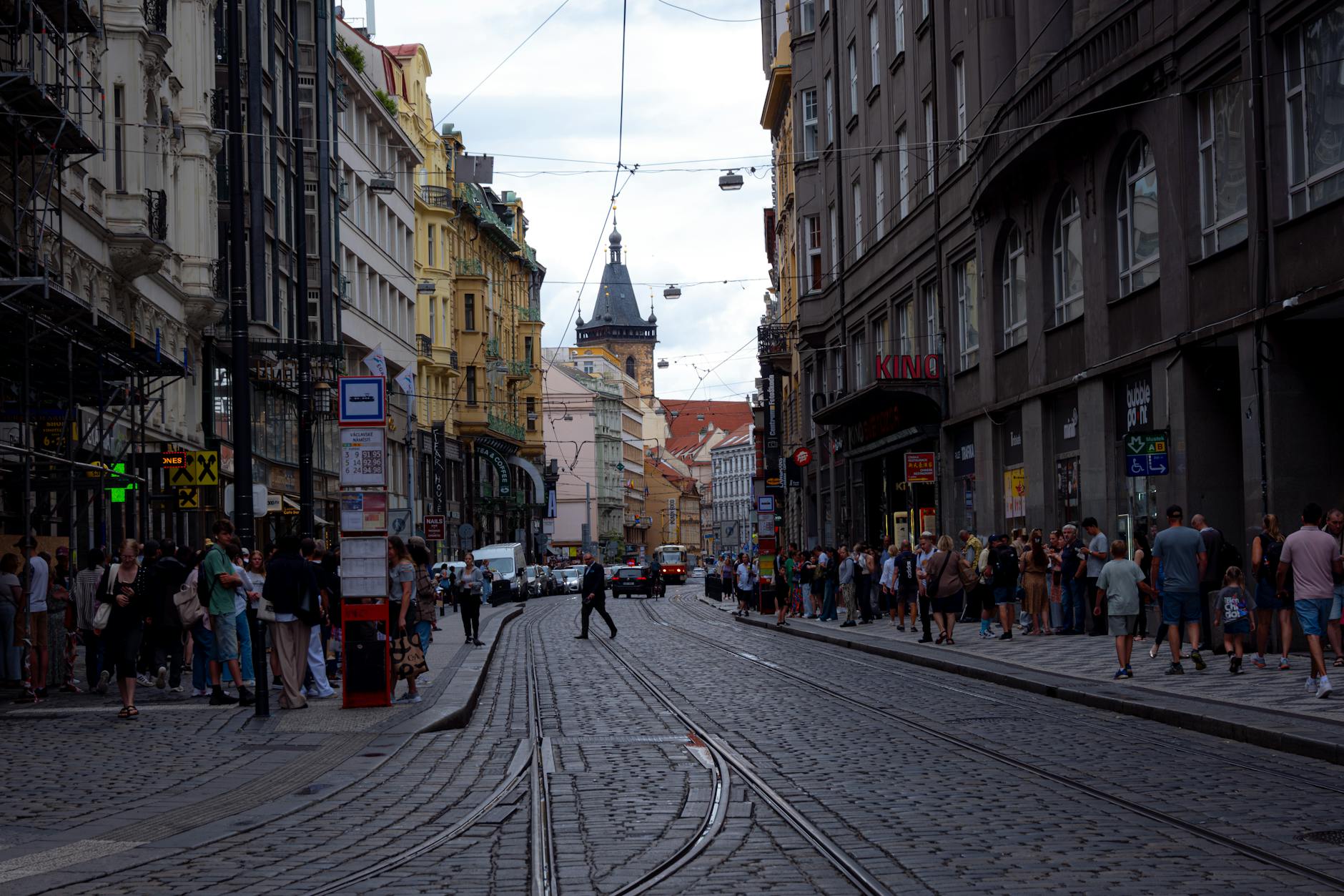 Busy Prague street with tram lines and historic buildings
