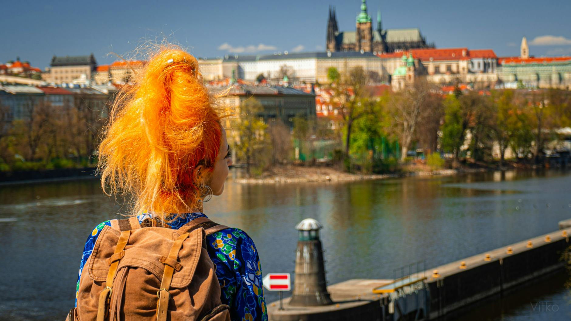 Woman with a backpack overlooking Prague and the Vltava River
