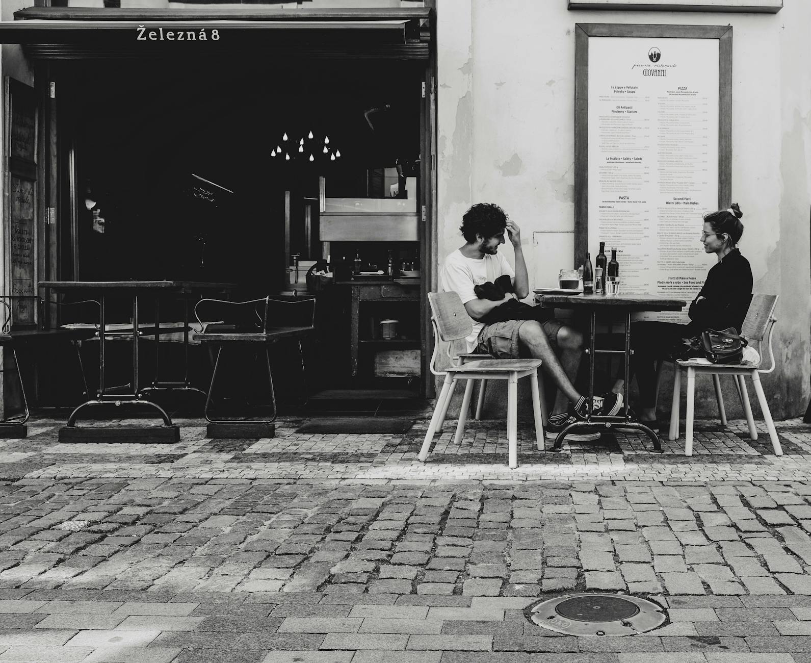 People enjoying drinks at a Prague cafe on a historic street