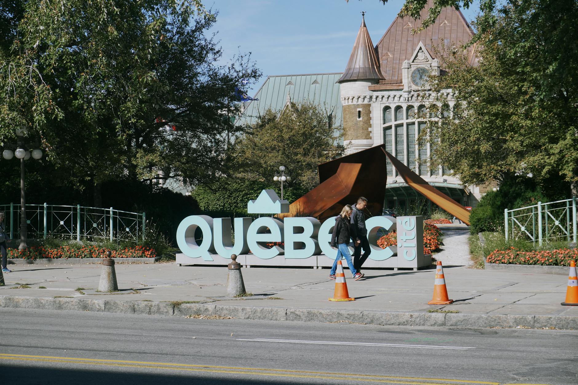 Travelers walking near a Quebec City sign