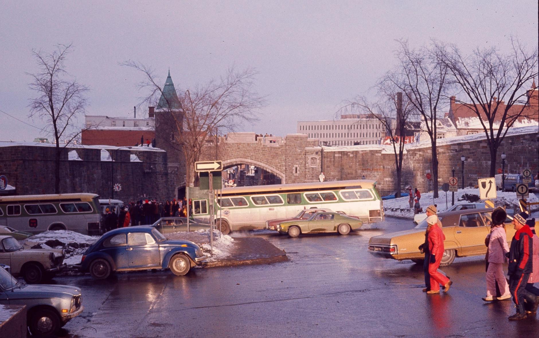 Winter street near Porte Saint-Jean in Quebec City with buses and pedestrians
