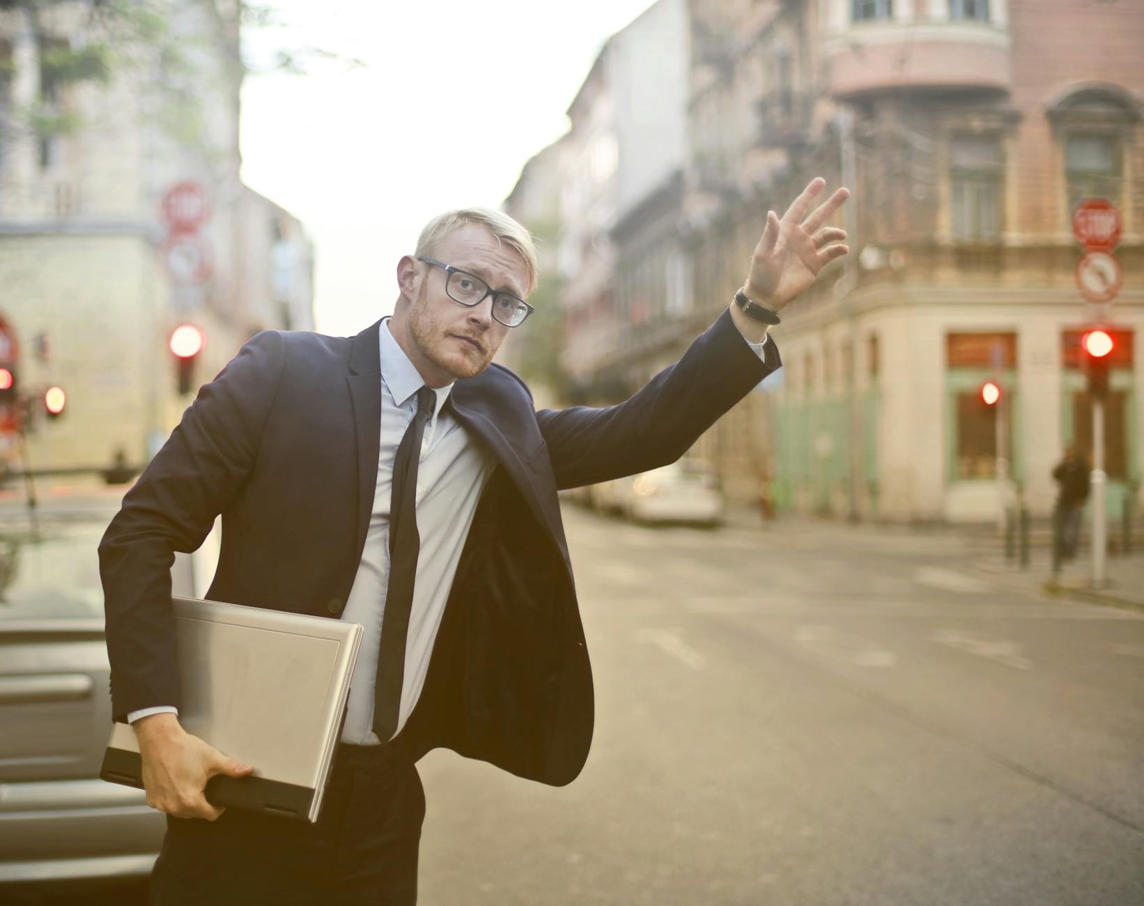 Businessman hailing a taxi while holding a laptop