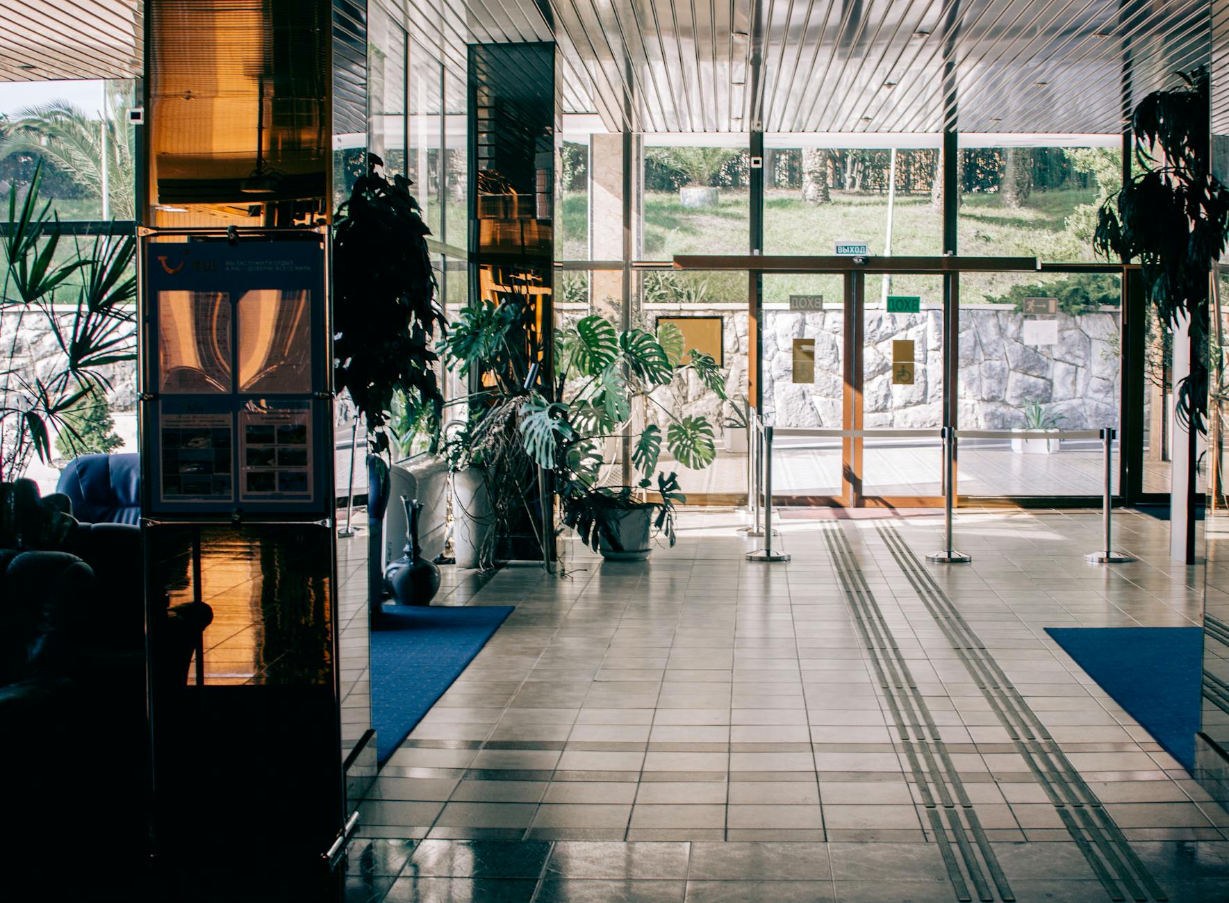 Modern hotel lobby with glass entrance and indoor plants
