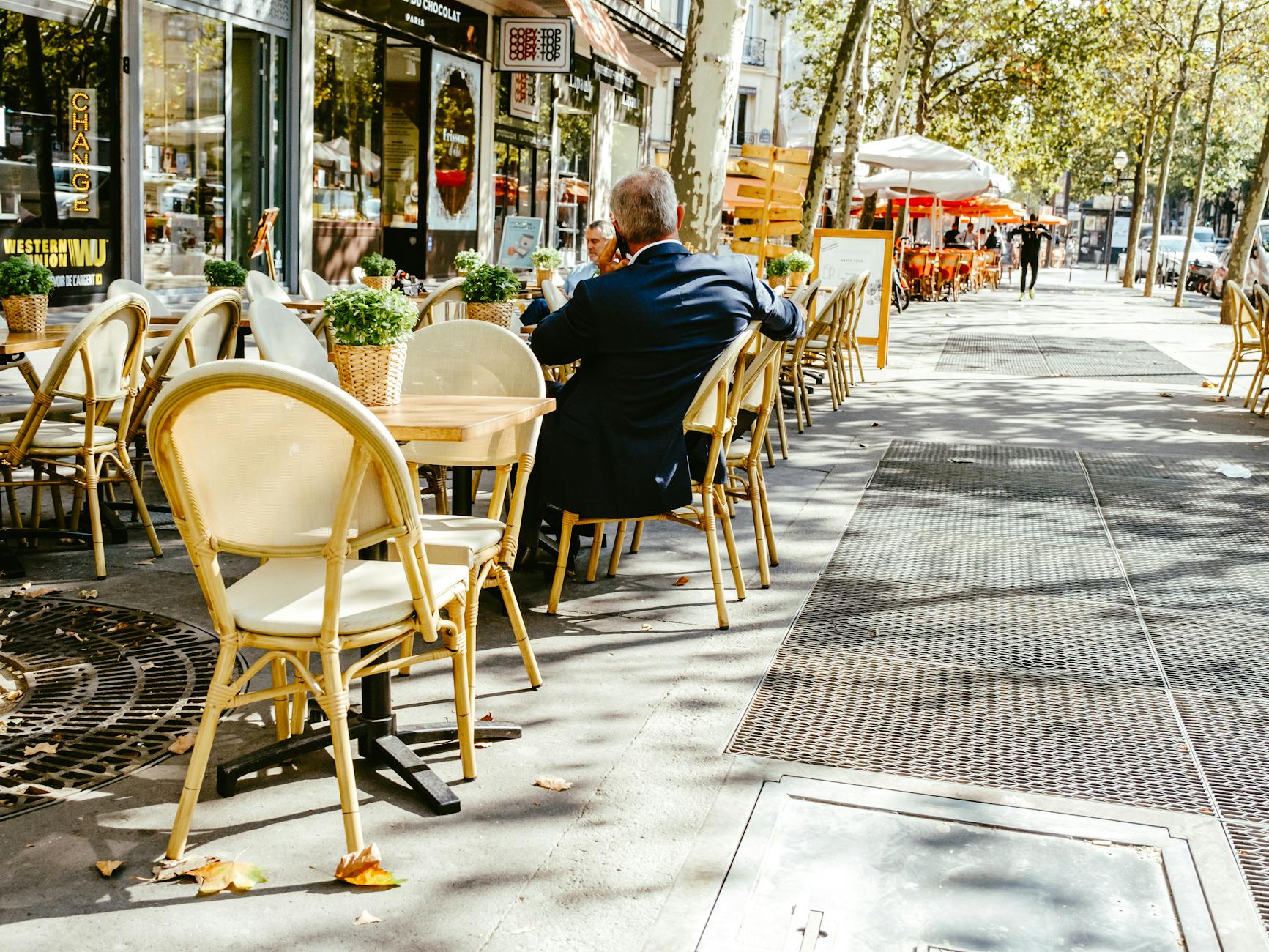 Businessman making a phone call at an outdoor cafe table