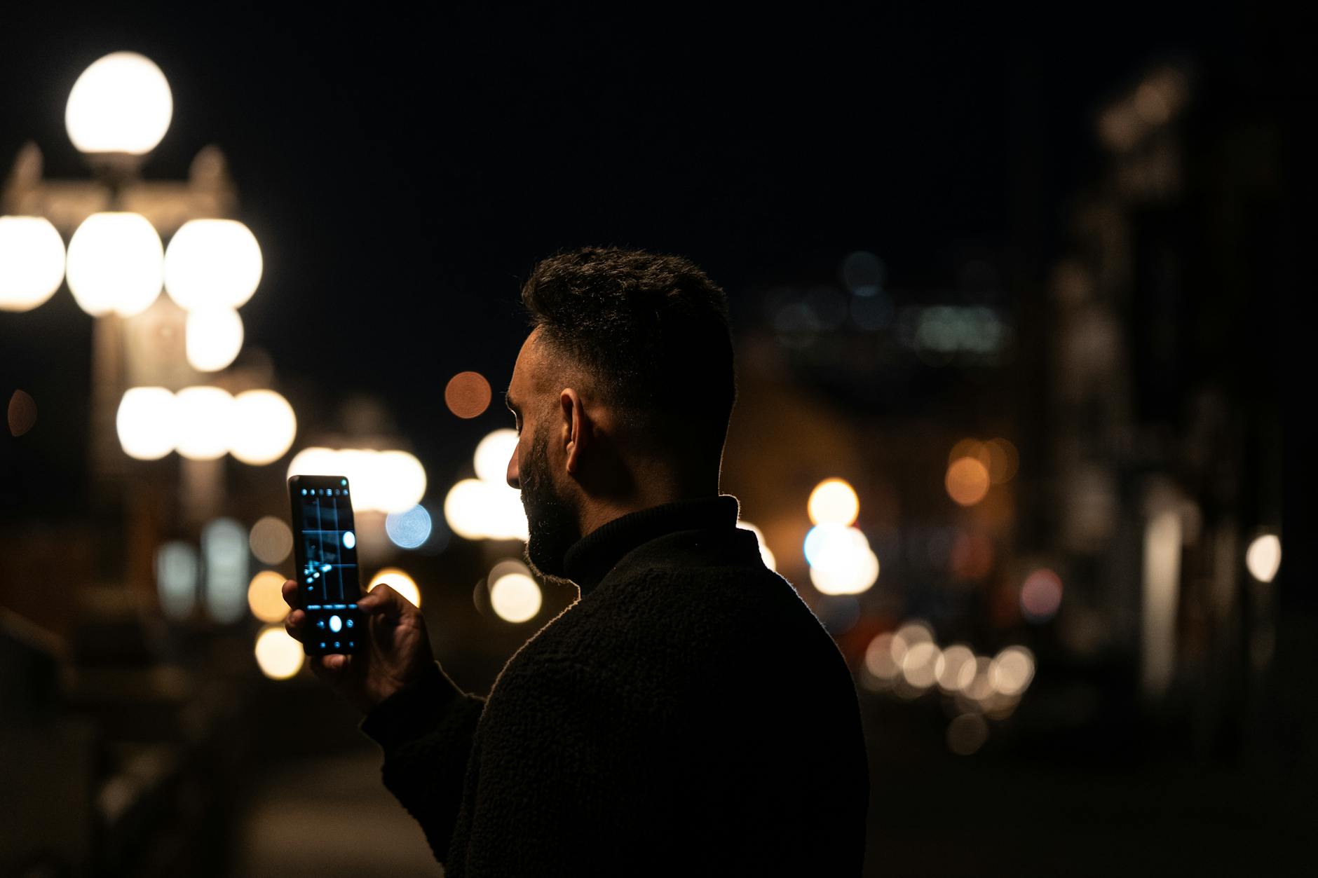 Person capturing Quebec City night lights on a smartphone