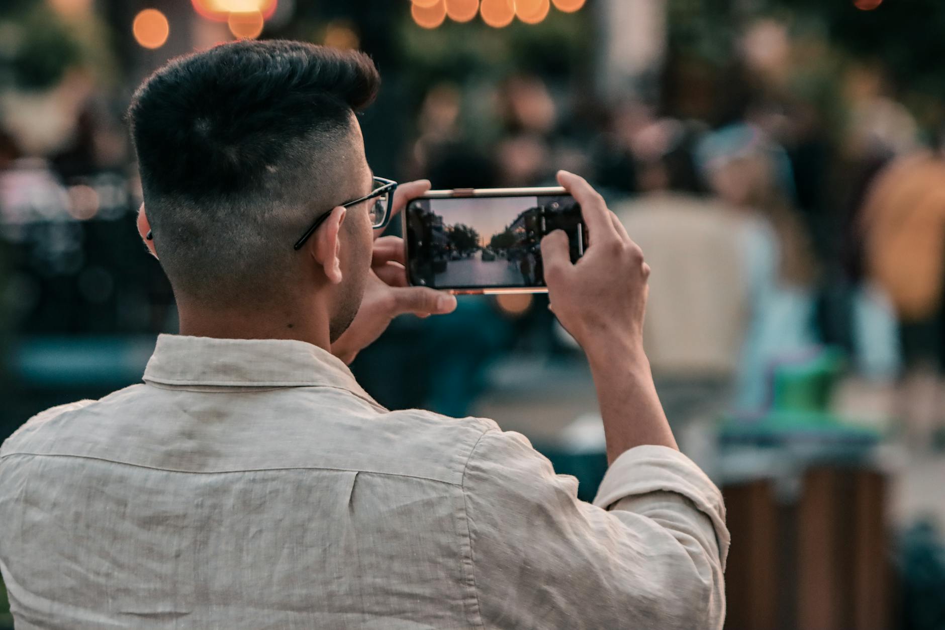 Person photographing a street scene with a smartphone