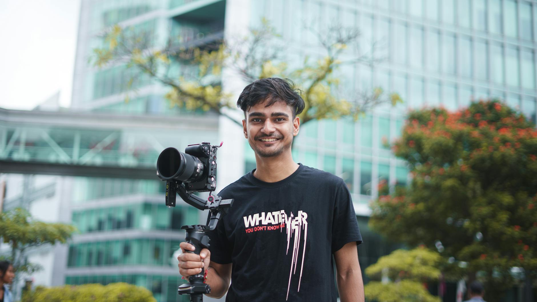 Young filmmaker holding camera equipment outdoors