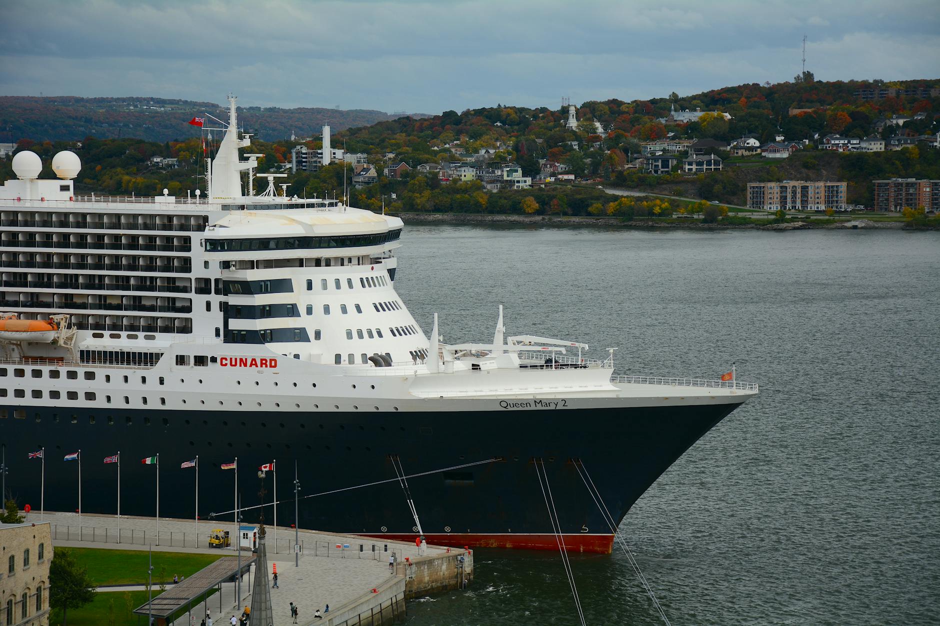 Large cruise ship docked at a scenic harbor