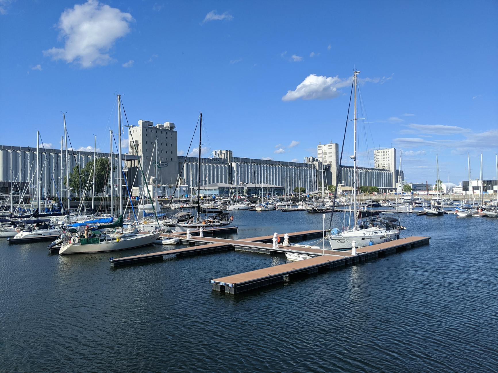 Sailboats anchored at a Quebec City marina under a clear sky