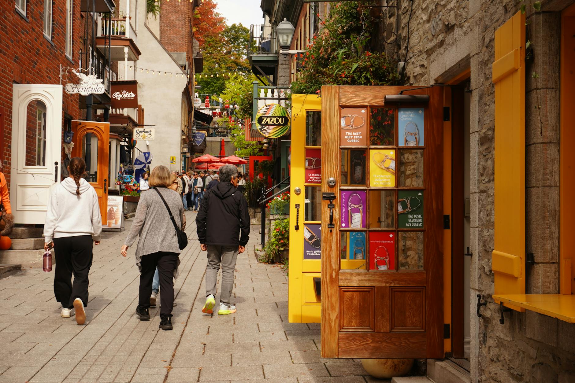 People strolling past colorful shops on a Quebec City street