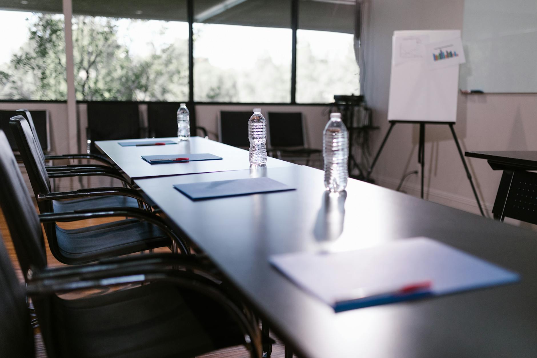 Conference room table set with water bottles and notes