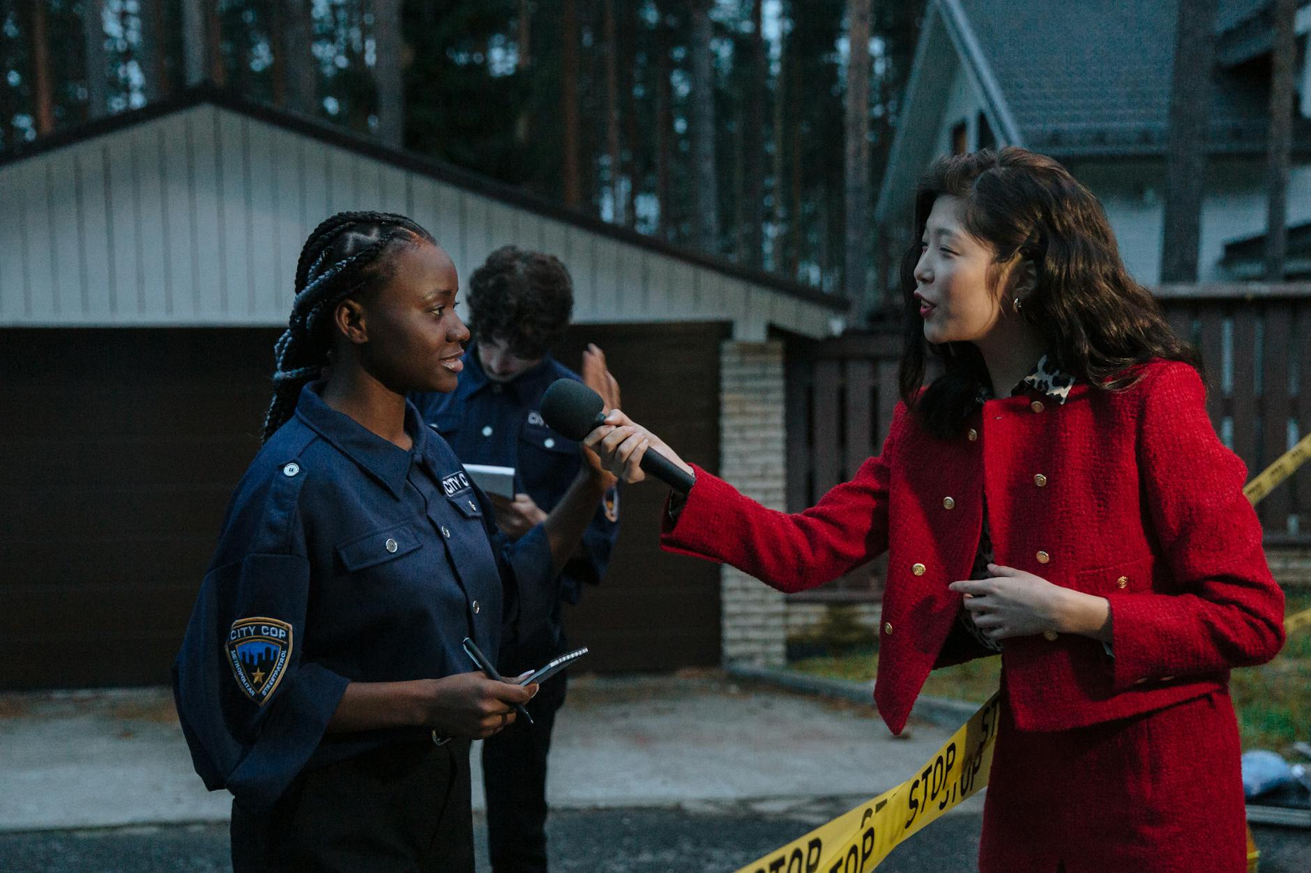 Journalist interviewing a policewoman outdoors at twilight