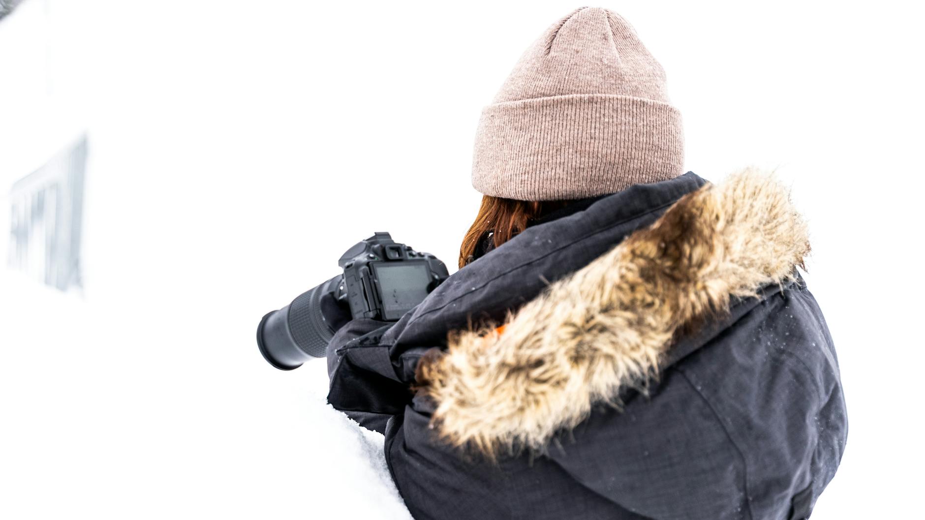 Photographer in winter clothing taking pictures in snowy Quebec City