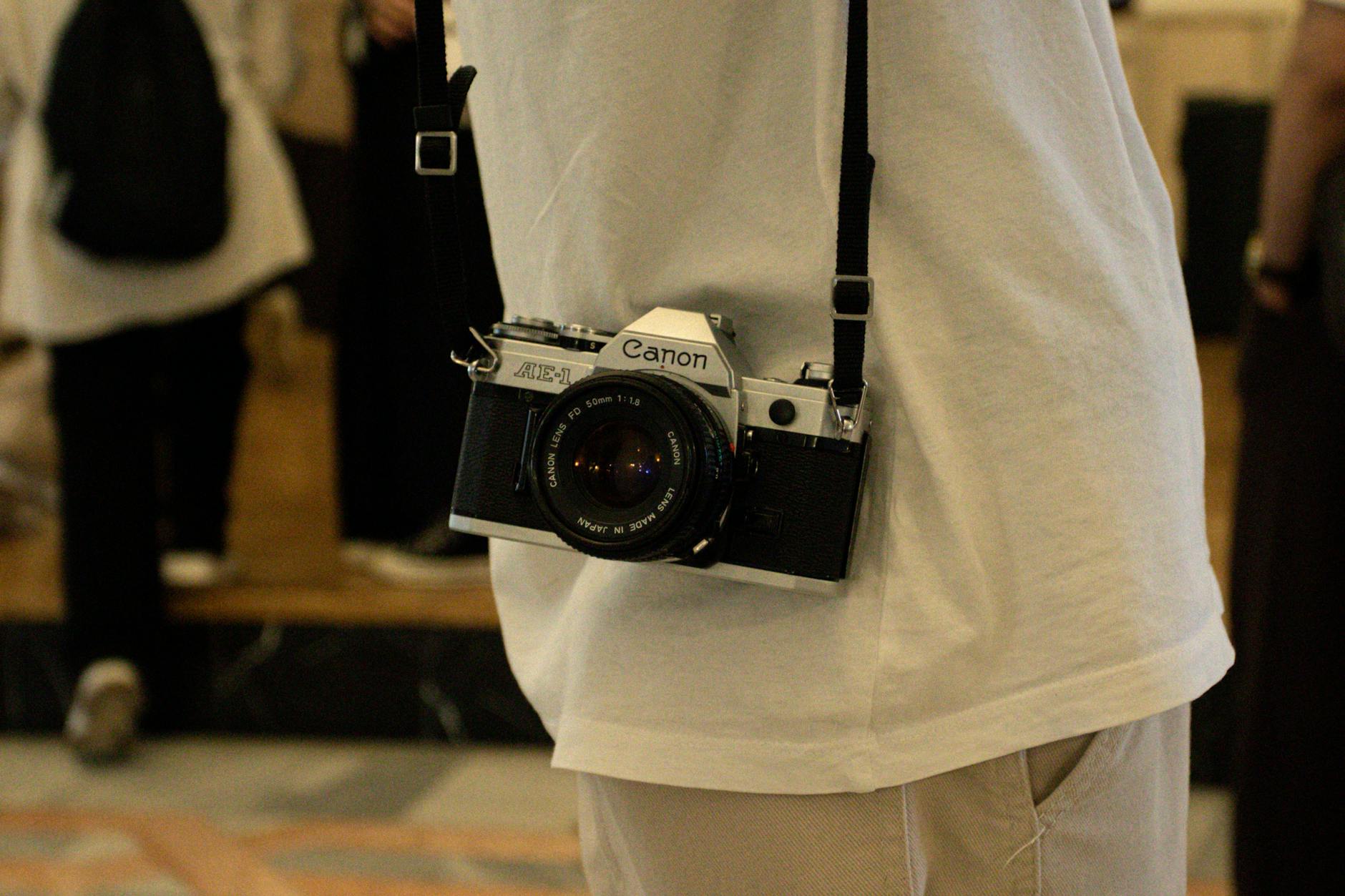 Close-up of a vintage camera hanging from a person's neck