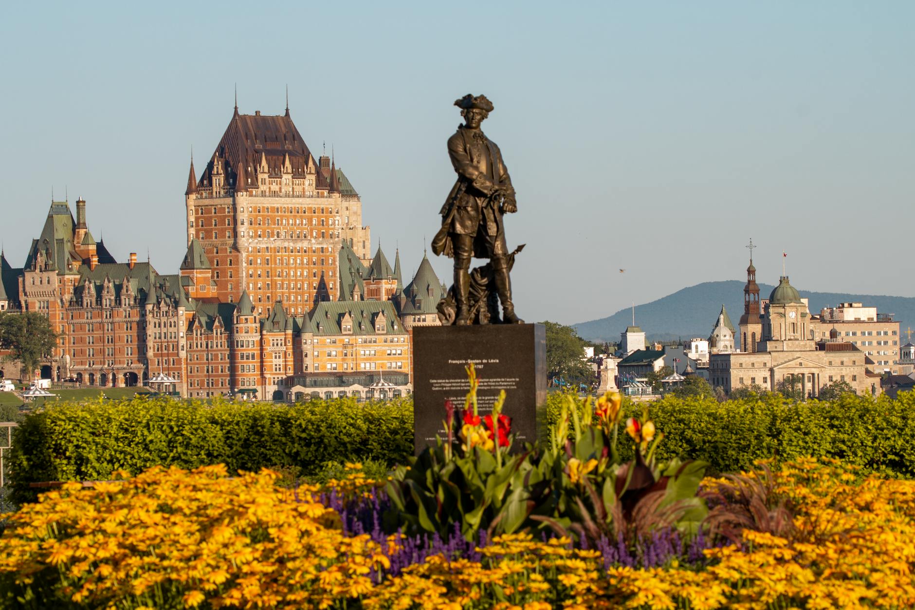 Sunny view of Chateau Frontenac with a statue in Quebec City