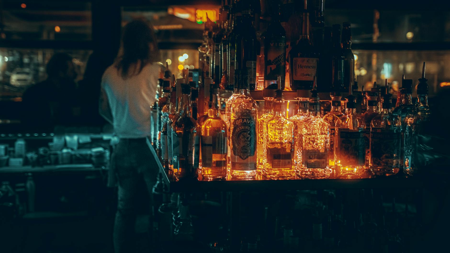 Moody bar interior with glowing liquor bottles