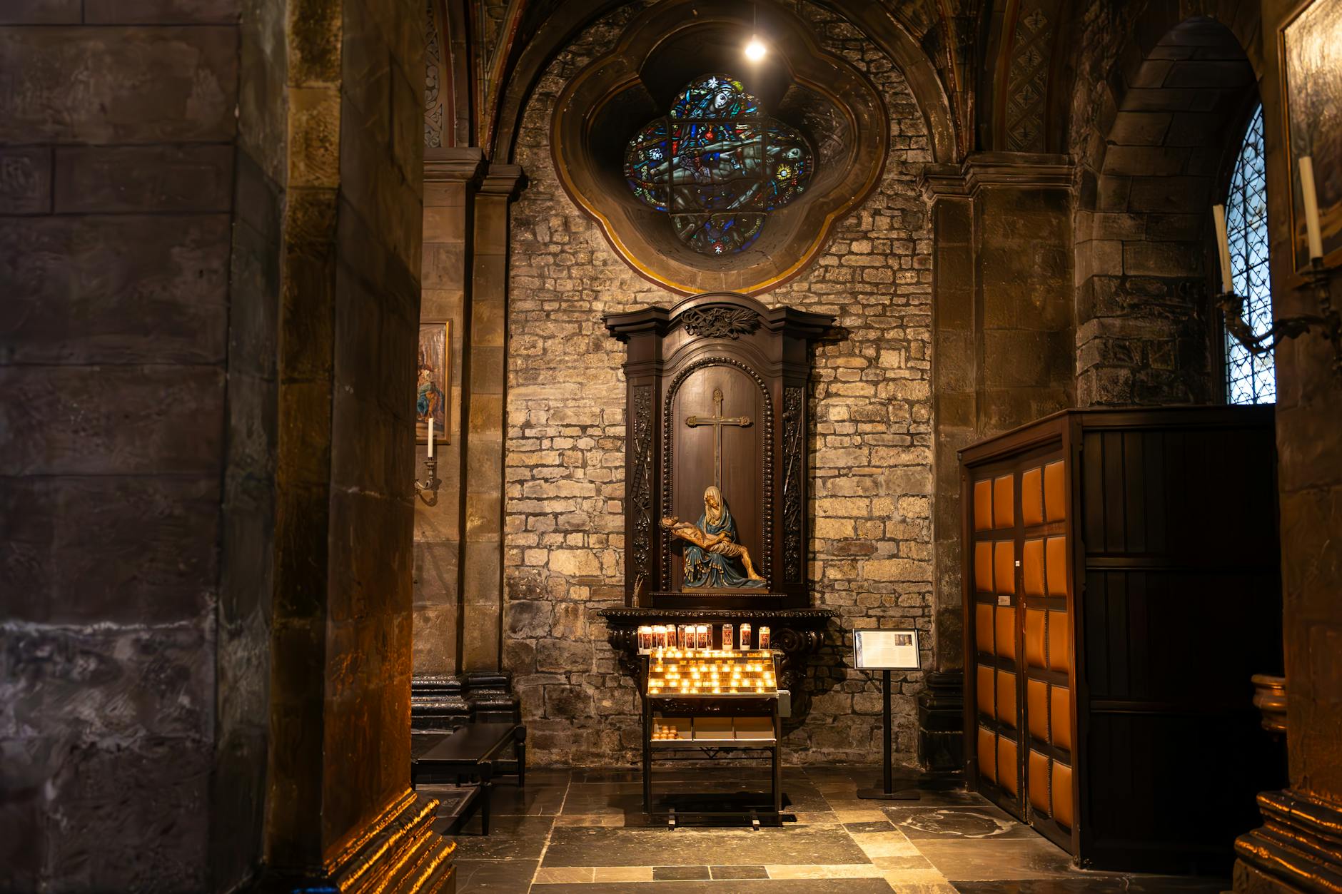 Quiet chapel interior with stained glass and candles