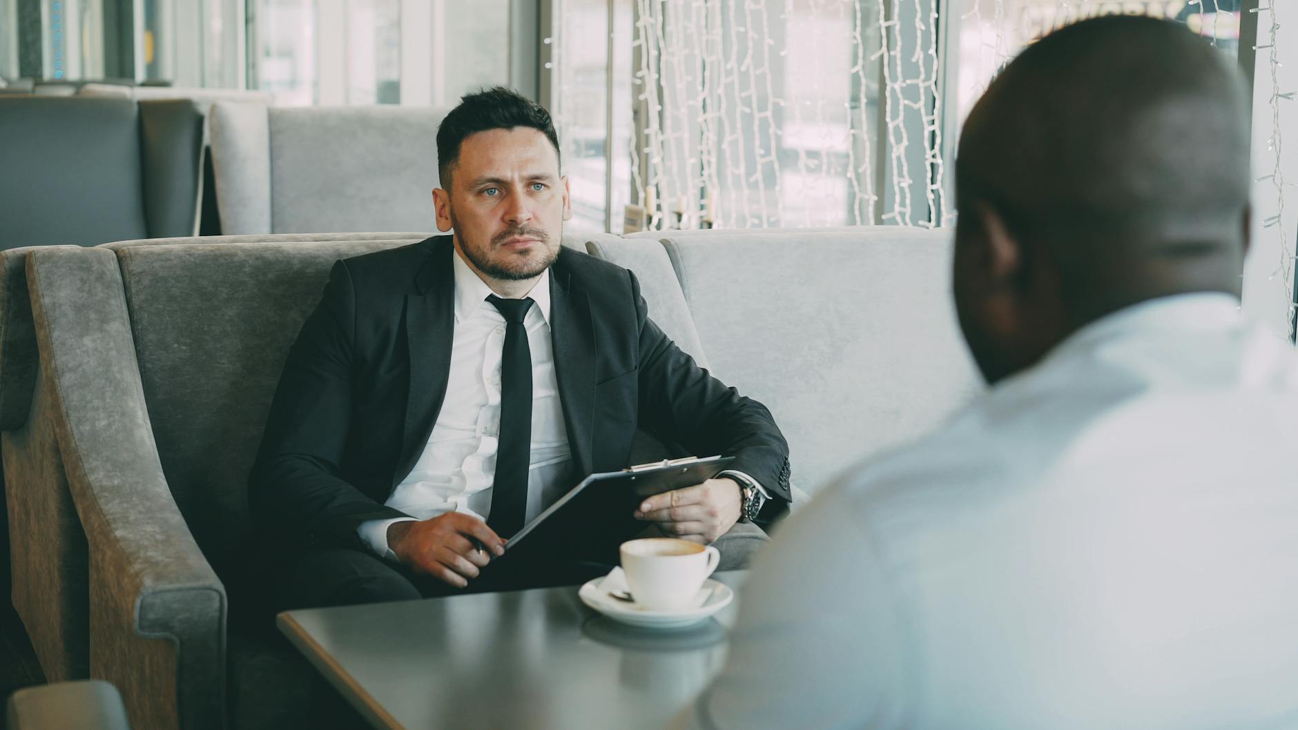 Two businessmen having a serious conversation over coffee in a cafe