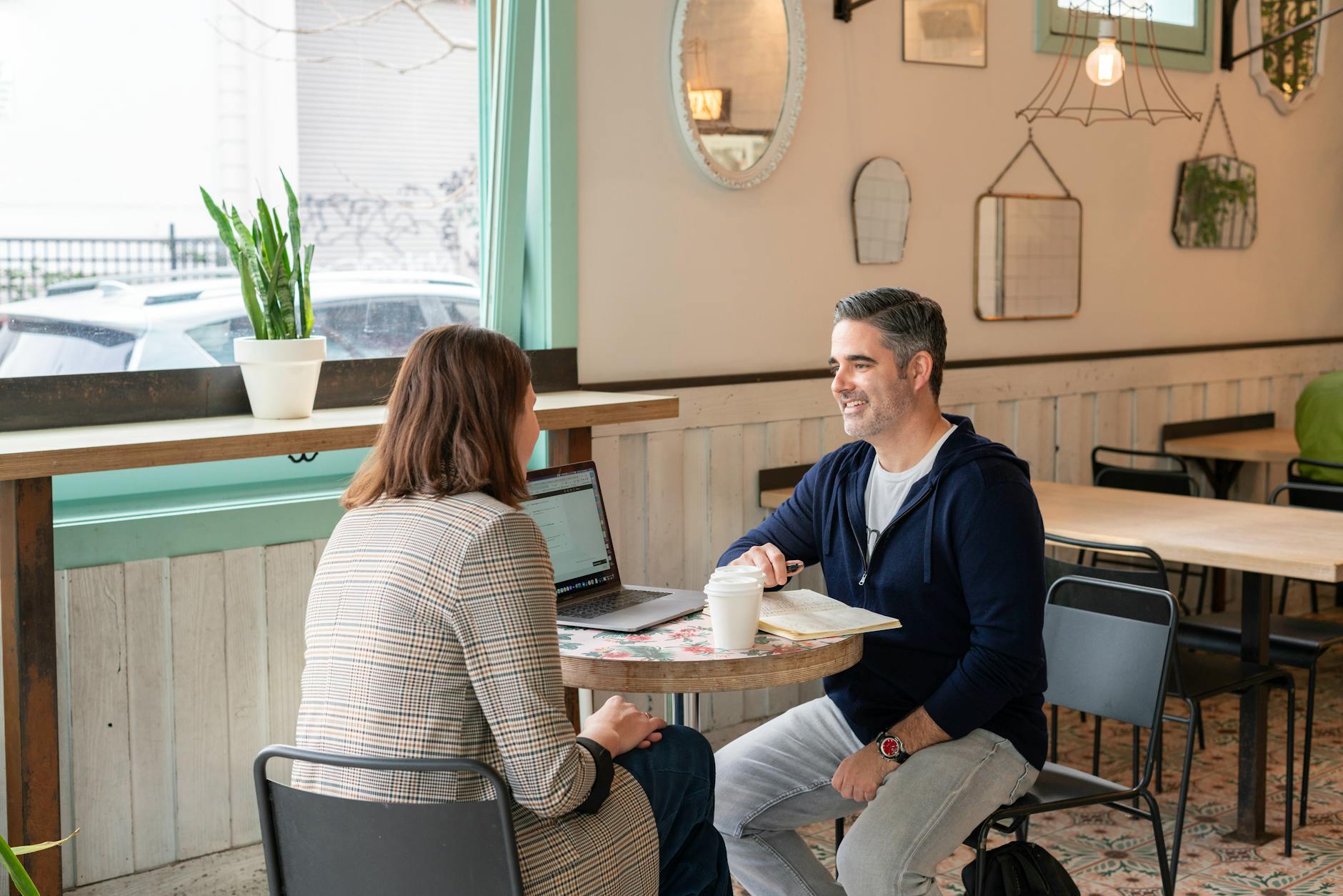 Two adults having a business discussion over coffee in a modern cafe