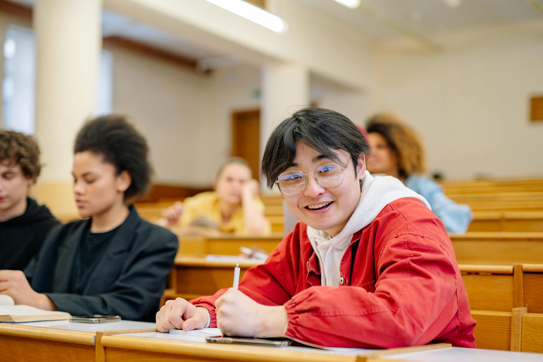 Student taking notes in a university lecture hall