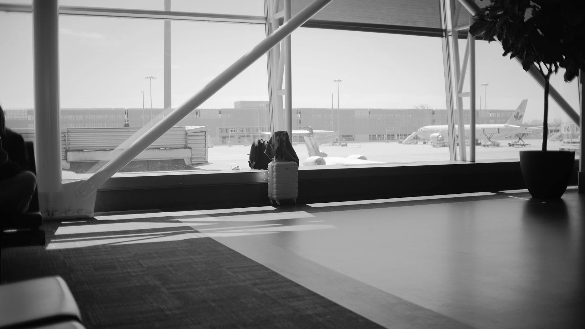 Airport lounge with luggage and an airplane outside