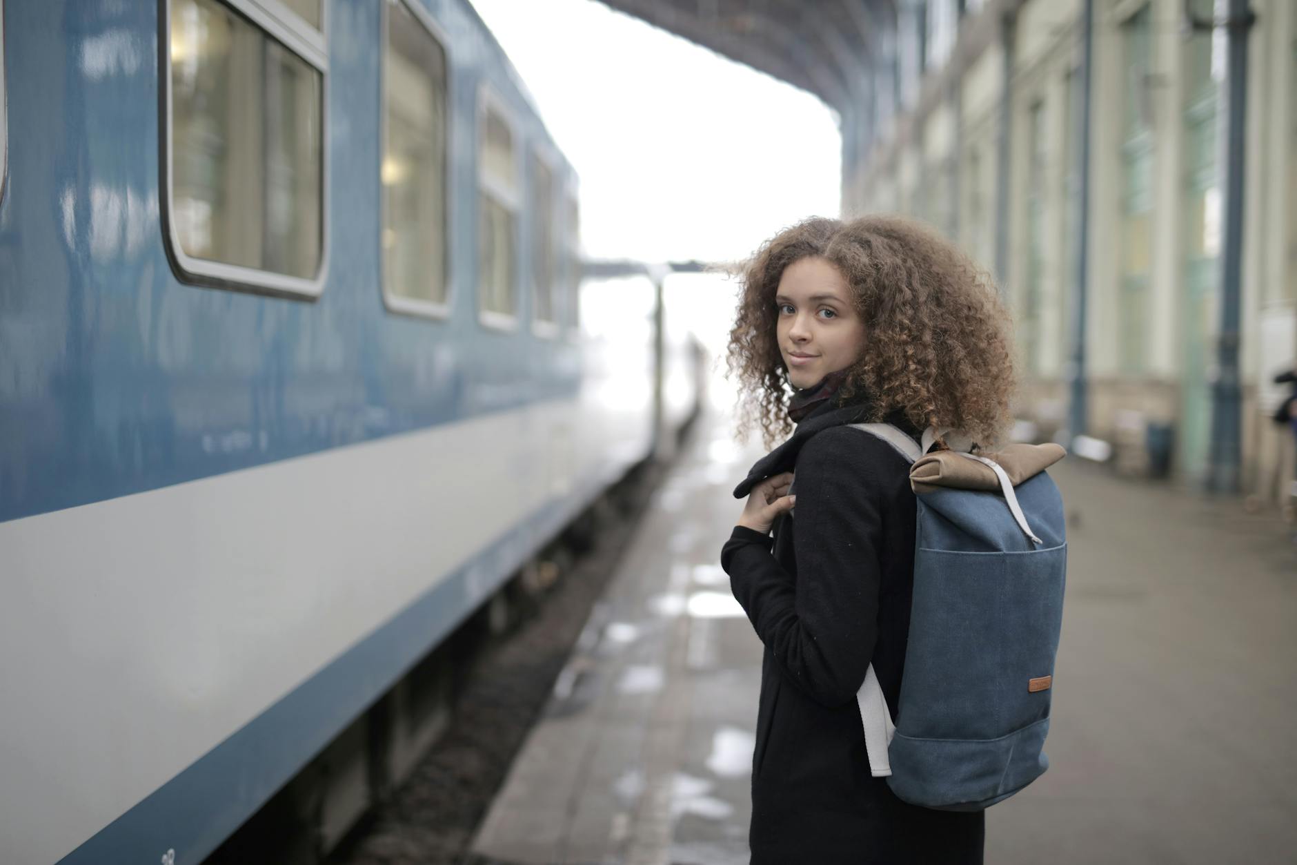 Traveler with backpack waiting at a train station platform