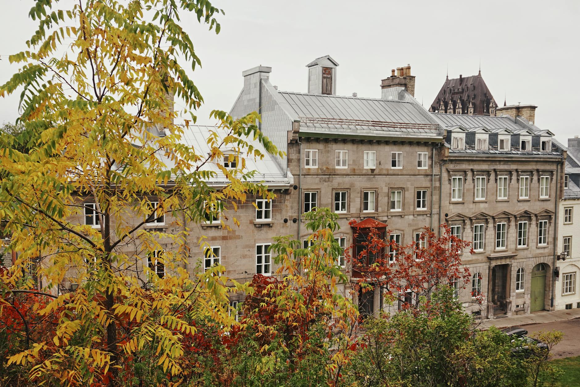 Historic Quebec City buildings framed by autumn foliage