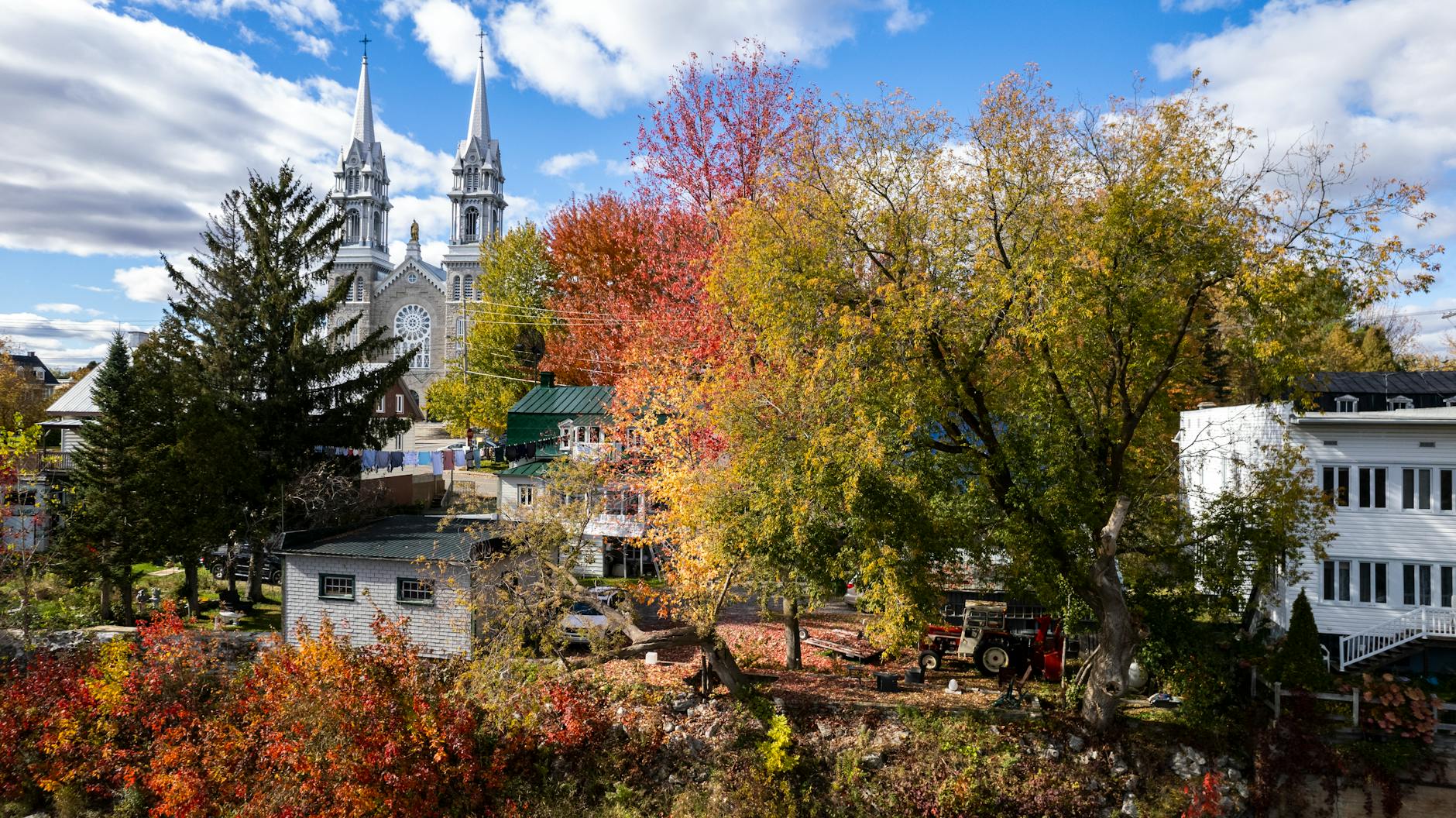 Aerial view of a Quebec village with autumn foliage and a historic church