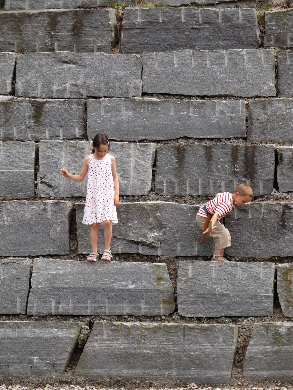 Children balancing on a stone wall for Stavanger family meal and break planning.