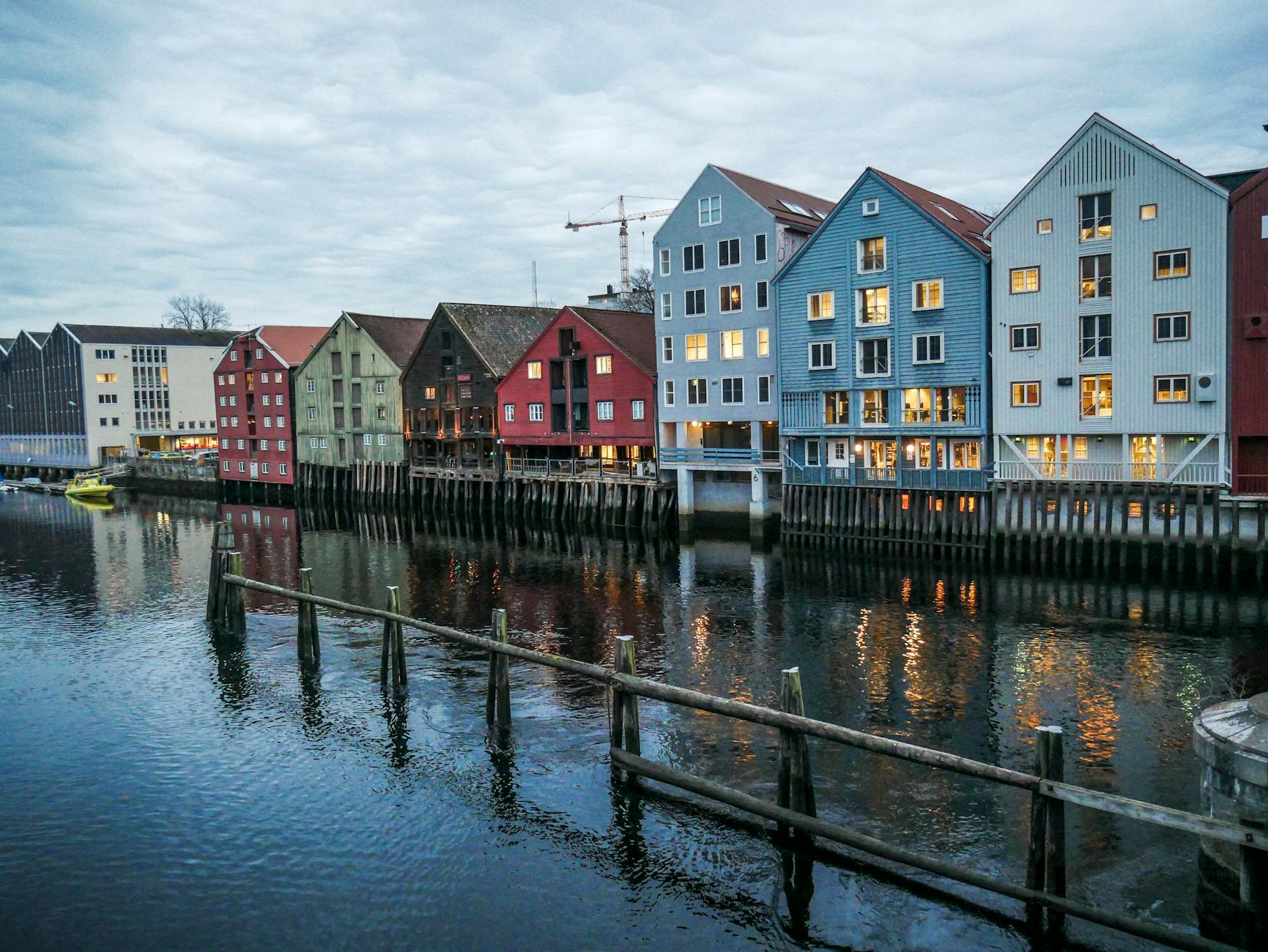 Modern waterfront residences under cloudy sky for Stavanger weather planning.