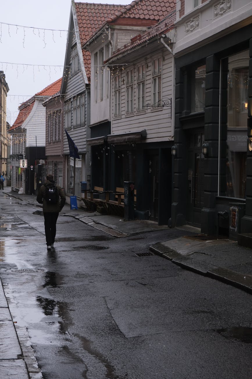 Rainy European street with lone pedestrian for Stavanger solo arrival planning.